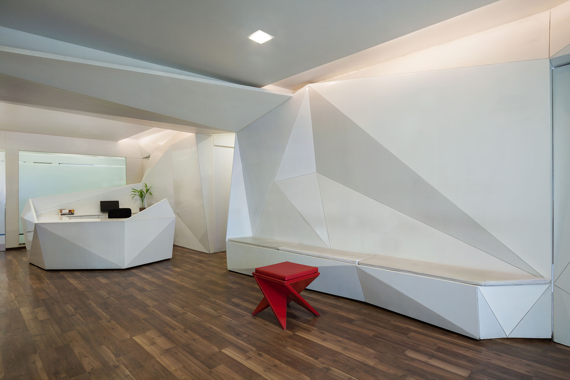 The main feature wall in the reception and waiting area folds to envelope a bench for patients. At the other end the wall folds out forming the reception table.
