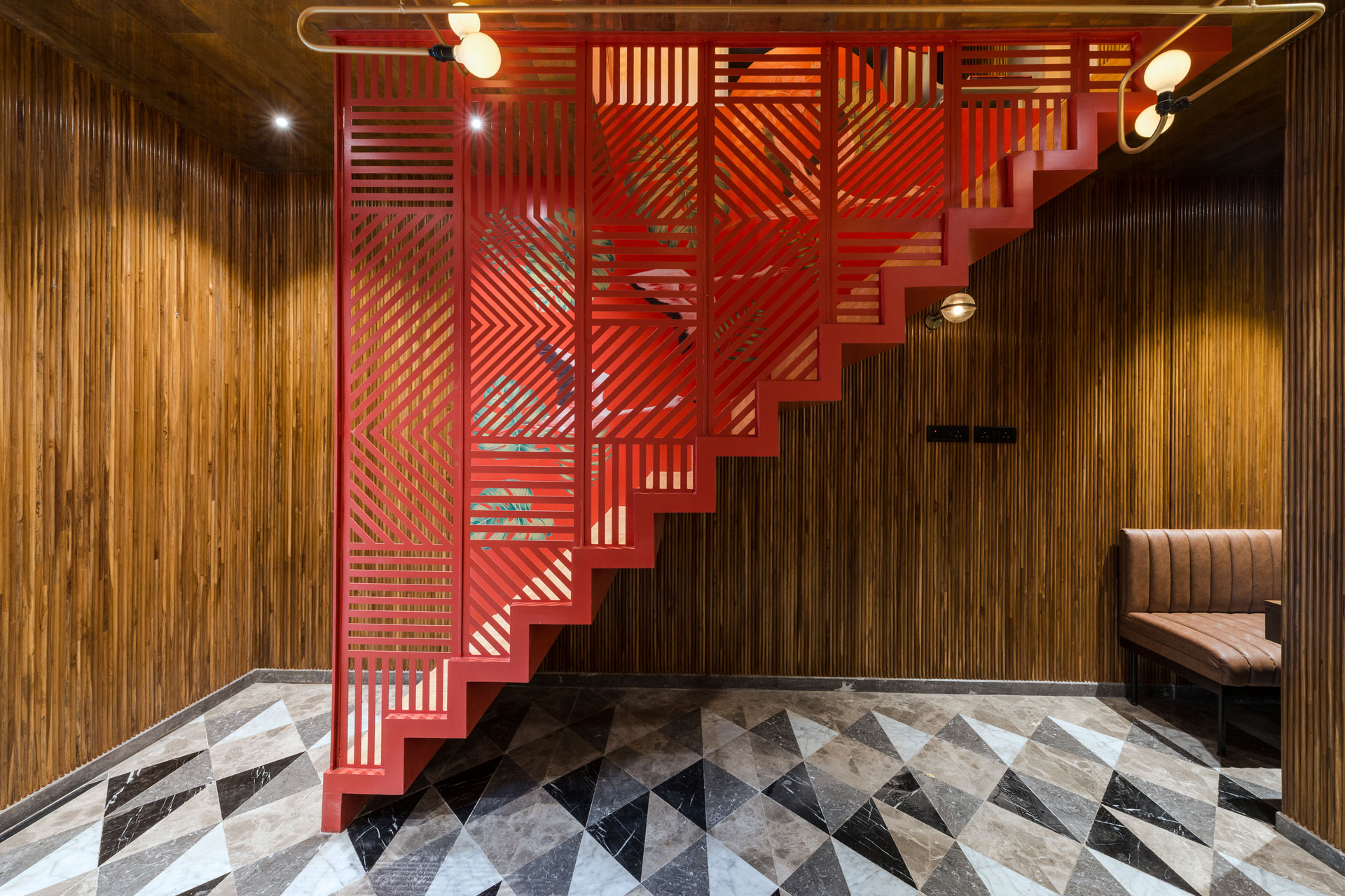 The staircase, leading to the upper level, is treated as a red box insert which has hand-painted flying up the stairs flamingos on one side and a cutwork metal screen on the other.