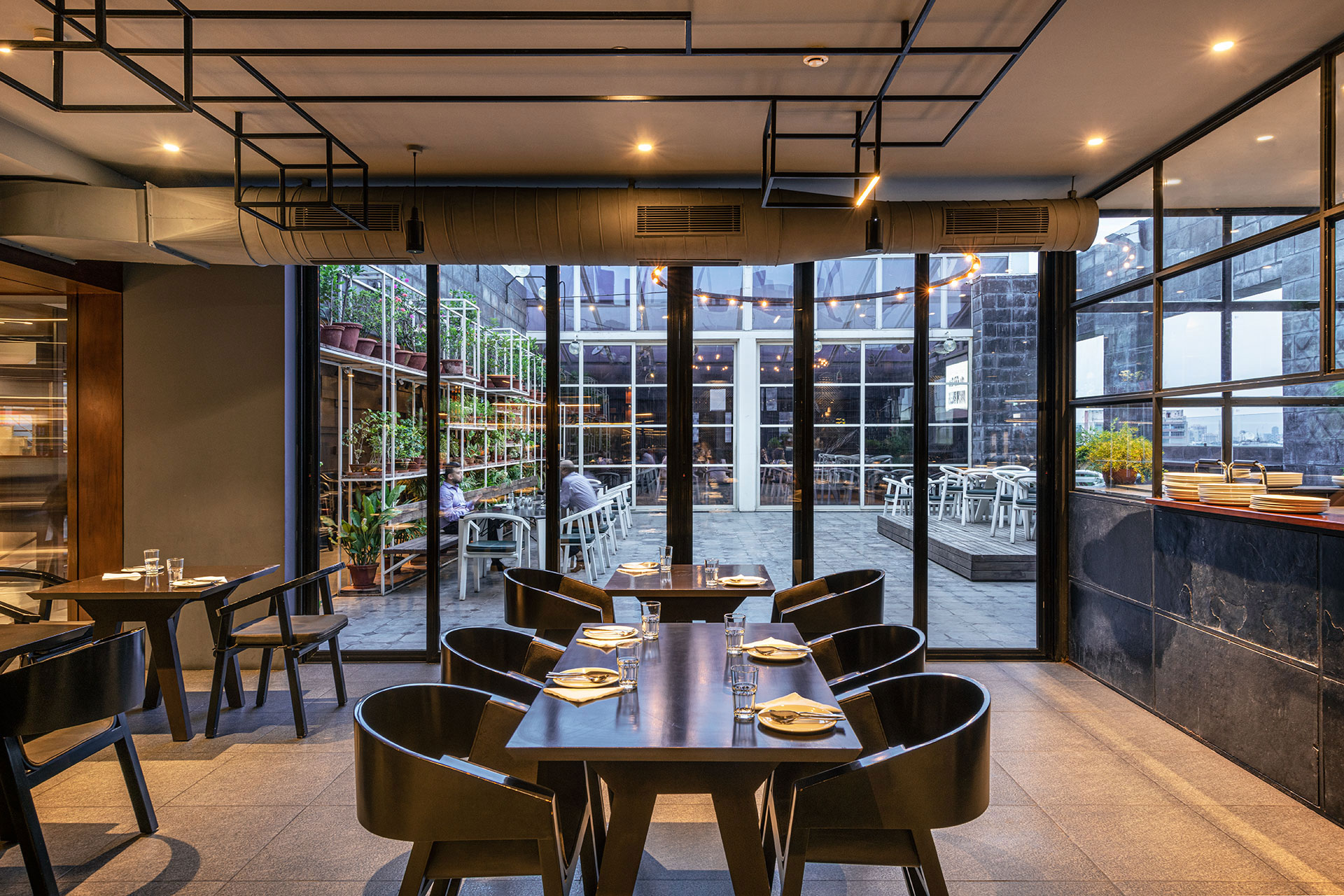 The formal indoor dining space is darker, and quieter, in terms of its use of materials, textures and colours.  Distinct in their feel, and offering different experiences, the three spaces still stand together as one large space, when the large sliding panels are opened up, connecting all three spaces.